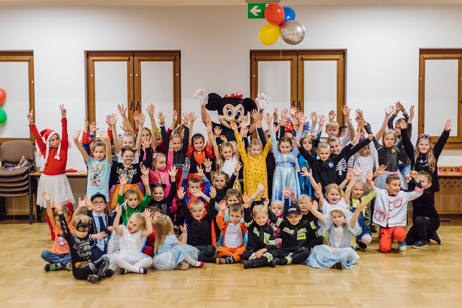 Dzieci w przebraniach z maskotką Myszki podczas balu