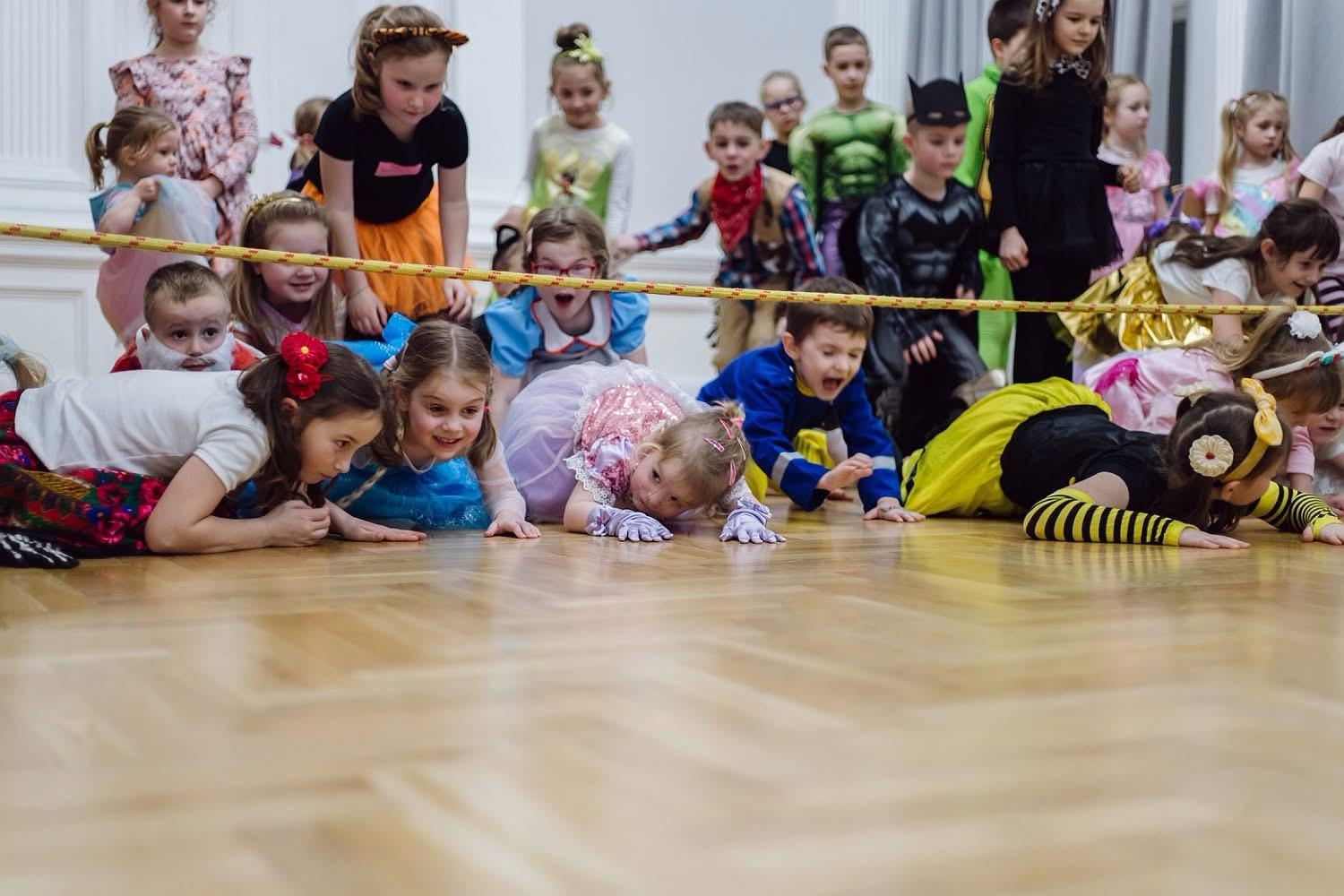 Dzieci czołgają się pod liną podczas konkursu